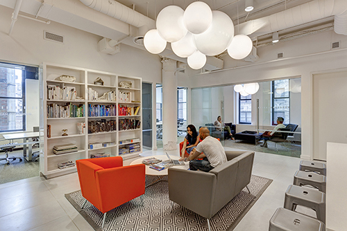 In the open library at Compass, a fast-growing NYC residential brokerage firm, Ted Moudis Associates uses the client’s existing books and arranges them by color to create a bold focal point in a neutral-colored lounge. Photography: by Brent Gollnick